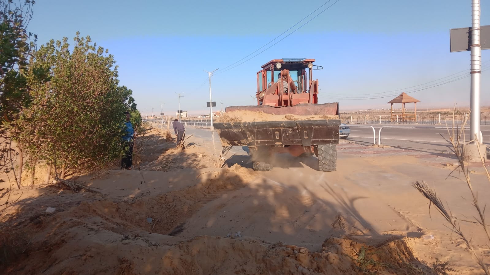 إزاحة الرمال وإعادة حفر الجور وإزالة النباتات الغريبة في طريق الخارجة أسيوط