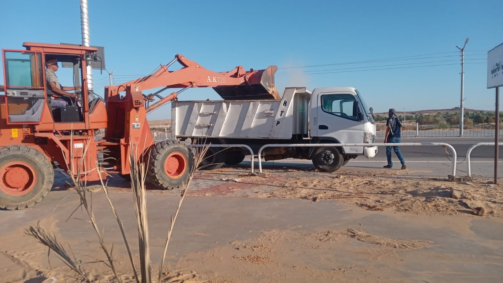 إزاحة الرمال وإعادة حفر الجور وإزالة النباتات الغريبة في طريق الخارجة أسيوط