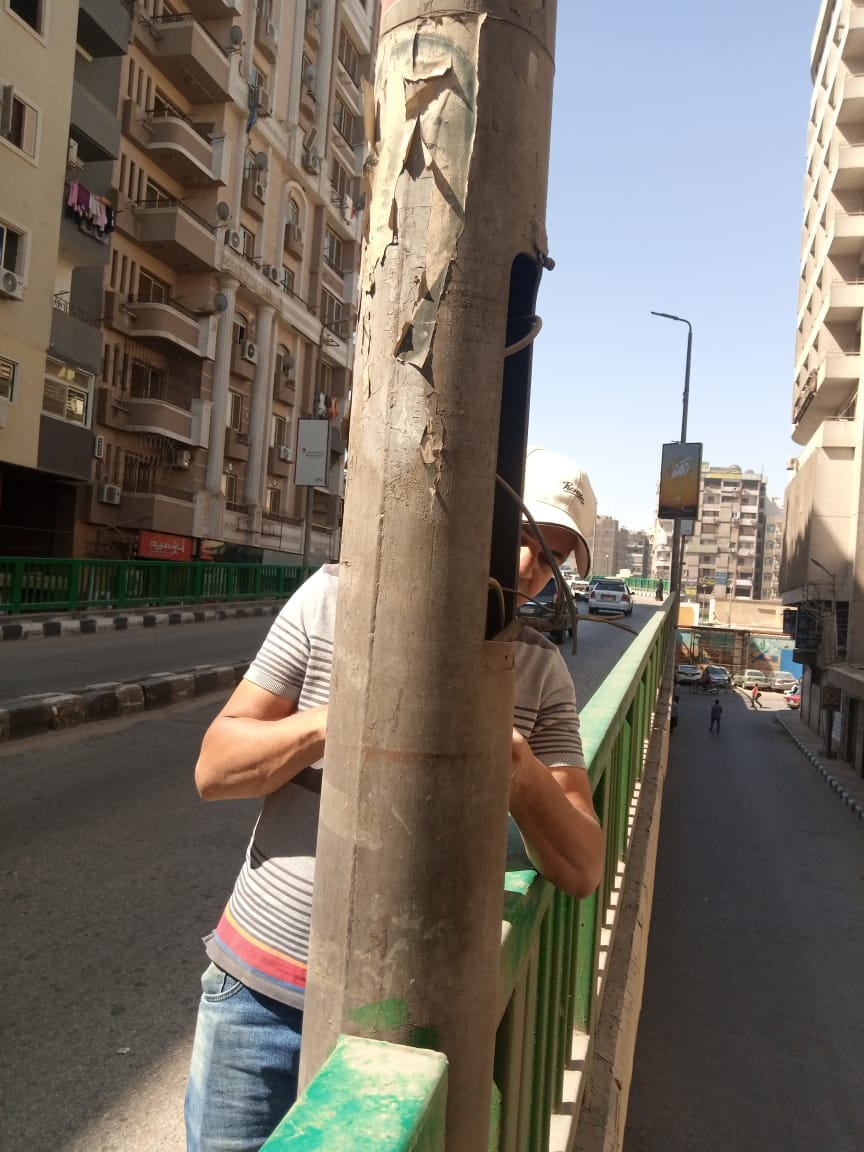 حي شرق اسيوط يقوم بمراجعة شاملة لأبواب الأعمدة الموجودة على كوبري الهلالي