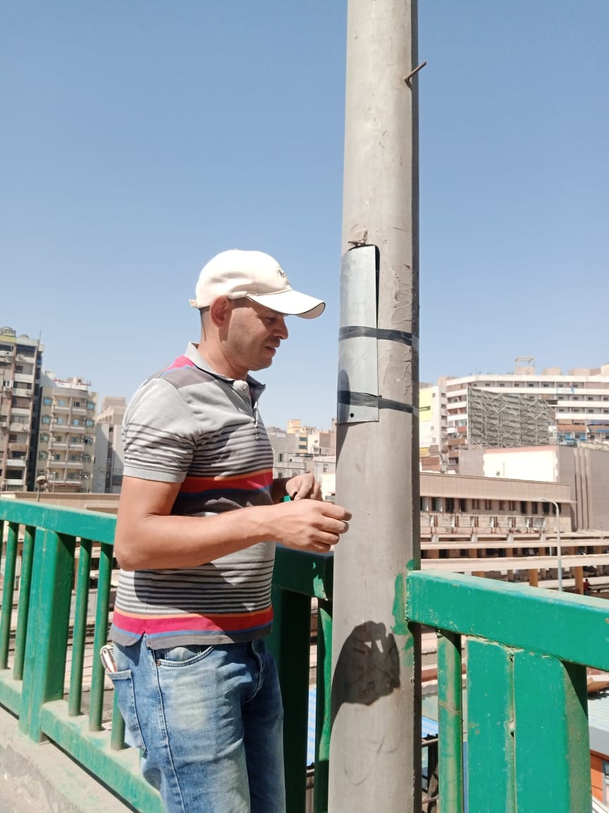 حي شرق اسيوط يقوم بمراجعة شاملة لأبواب الأعمدة الموجودة على كوبري الهلالي