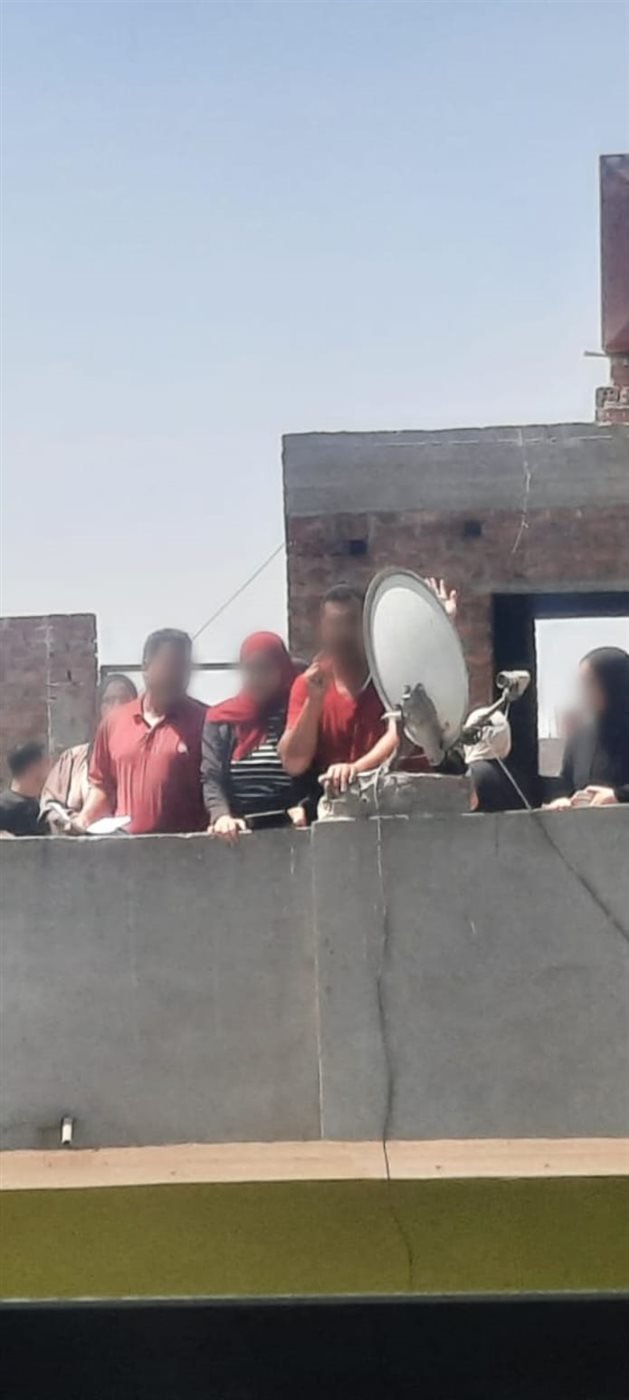 المعلم صعد على مبنى لارسال الاجبات أمام لجنة مدرسة بالجمالية