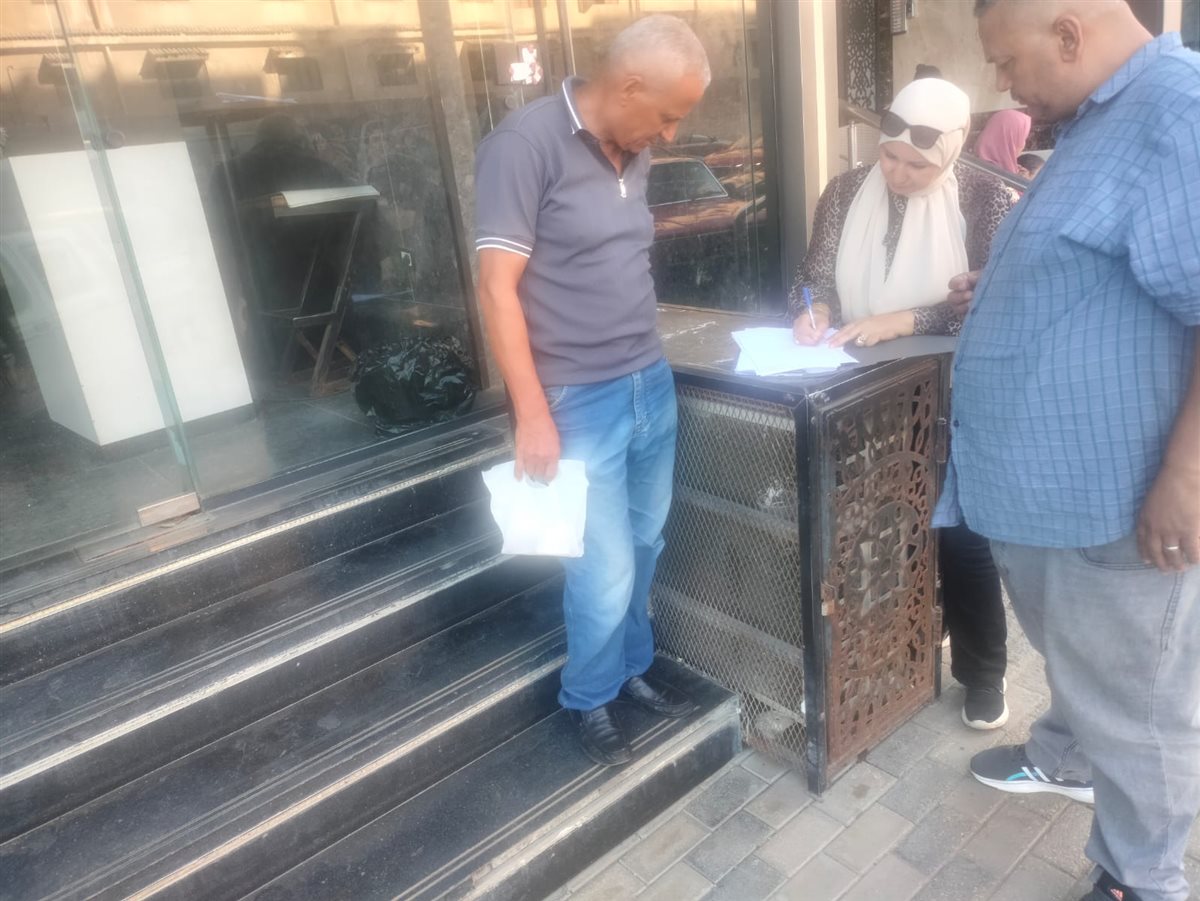 اللجنة خلال أعمال تشميع المحل