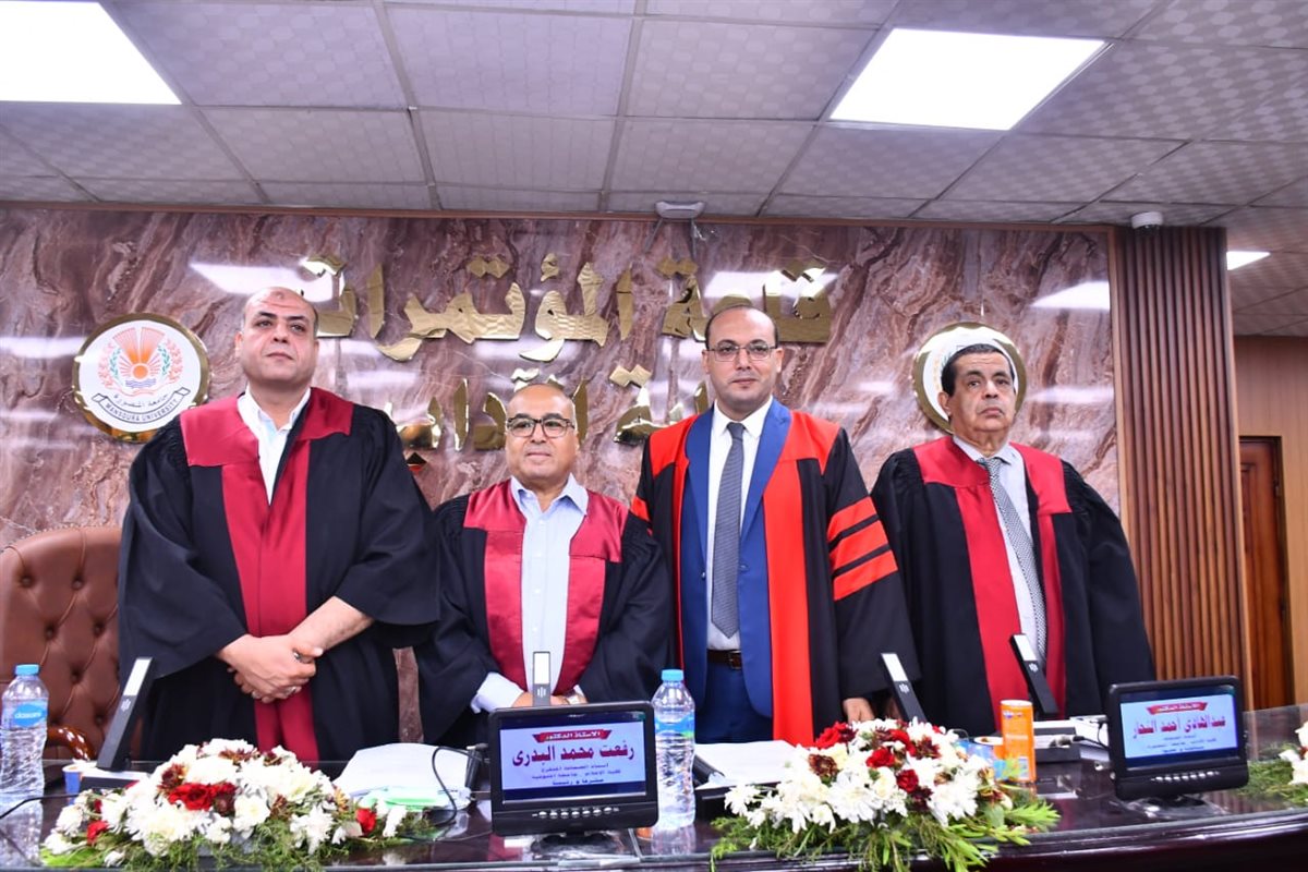 الباحث يتوسط لجنة المناقشة والحكم