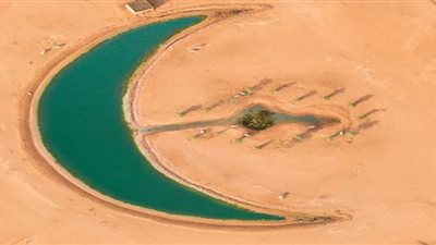 على شكل هلال.. مصور يوثق بحيرة ساحرة في صحراء دبي