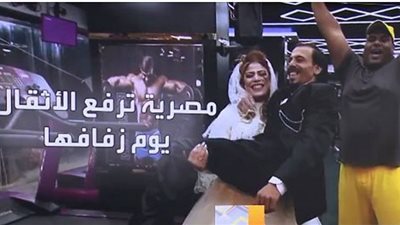 بطلة مصارعة تحمل عريسها بيد واحدة يوم زفافها.. شاهد