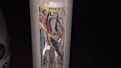 تغطية الأسلاك المكشوفة بأعمدة الإنارة بحي شرق أسيوط