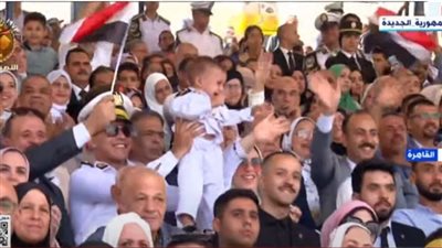 ضابط شرطة يحمل نجله أثناء احتفالية تخريج دفعة جديدة بالأكاديمية 