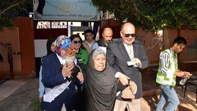 محافظ أسيوط يصطحب سيدة مسنة لداخل لجنة مدرسة الفاروق المتميزة للإدلاء بصوتها