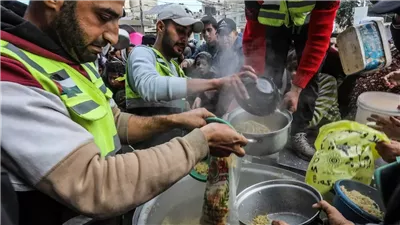 مواطنون يصطفون في طوابير للحصول على الطعام في دير البلح وسط غزة.. فيديو