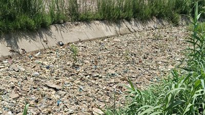 سائق كراكة يُثير غضب الأهالي بأتريس.. يزيح القمامة في الترعة جانبًا (فيديو وصور) 