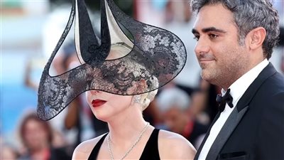 ليدي جاجا تتألق مع خطيبها على السجادة الحمراء لمهرجان فينيسيا 