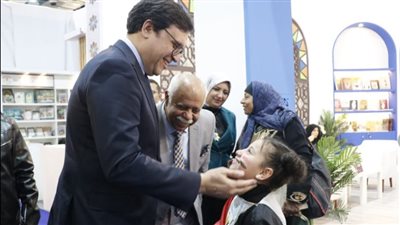 وزير الثقافة يصافح طفلة ترتدي علم مصر بمعرض الكتاب