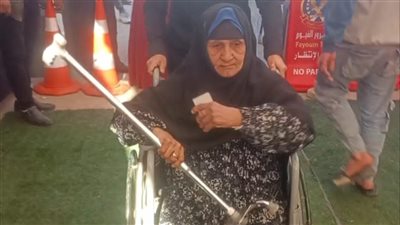 الأمن يساعد مسنة للإدلاء بصوتها في الانتخابات بالفيوم